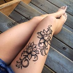 a woman's legs with tattoos on them and her leg showing the flower design