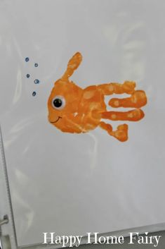 an orange handprinted fish on a white background with the words happy home fairy written below it