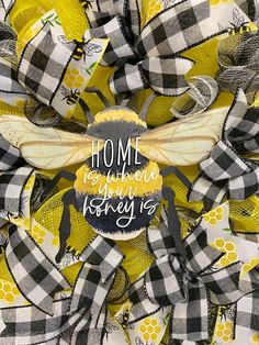 a yellow and black bee wreath with the words home is where your honey is on it