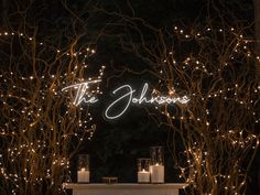 candles are lit in front of an archway decorated with branches and the word'the johnsons '