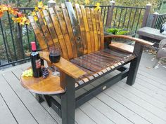 a wooden chair sitting on top of a deck next to a bottle of wine