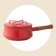 a red pot with a wooden handle and glasses on it