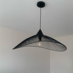 a black lamp hanging from the ceiling in a room