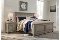 a bedroom with a bed, nightstands and a large clock on the wall above it