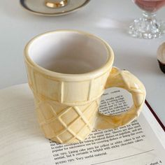 an ice cream cup sitting on top of a book next to a glass of wine