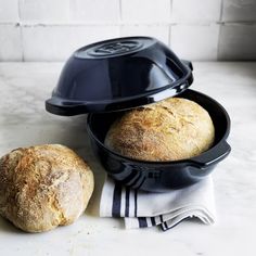 two loaves of bread sitting on top of a table next to a loaf of bread