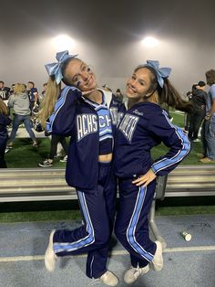 two cheerleaders are posing for a photo