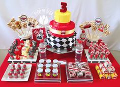 a red table topped with lots of desserts and drinks on top of it's sides