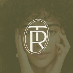 a woman holding her hand to her face with the letter r in front of her