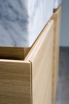 a close up of a drawer with marble on it's top and wood drawers