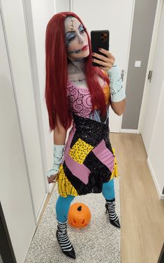 a woman with red hair and makeup is taking a selfie in her halloween costume