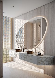 a modern bathroom with marble counter tops and large round mirror over the sink, along with two vessel sinks