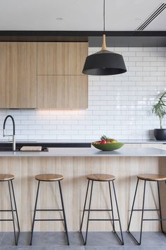 three stools sit in front of a kitchen island