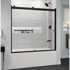 a bathroom with a glass shower door and black handles