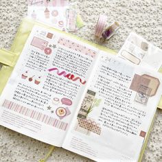 an open book sitting on top of a table next to some tape and other items