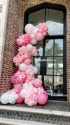 balloons are arranged in the shape of a tree on top of steps outside a building