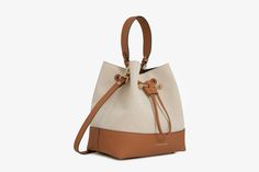 Our best-selling Osette is reimagined in a larger silhouette, for those who need a little more room. A modern take on the classic bucket bag, the soft structure is handcrafted in Spain from buttery-soft pebble finished leather and features an elegant drawstring closure, complete with our signature music bar. This versatile, midi silhouette encourages everyday use and can be carried in hand by the leather top-handle, or styled as a crossbody bag with the detachable leather strap. Experience the r Music Bar, Handbags Collection, Wardrobe Pieces, Handbag Collection, Designer Handbag, Natural Tan, New Wardrobe, Relaxed Style, Endless Possibilities