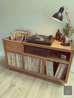 an old record player is sitting on top of a wooden cabinet with records in it