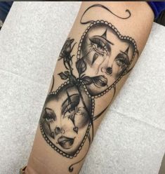 a woman's arm with tattoos on it and two faces in the shape of hearts