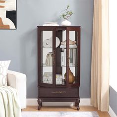 a living room with a white couch and blue walls in the corner, including a glass cabinet