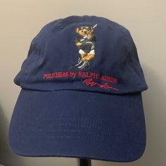 Navy Blue Designer Cap With Designer Signature. Embroidered Polo Bear Emblem, New Never Worn Navy Visor Hat With Embroidered Logo, Navy Embroidered Cap, Blue Hats With Embroidered Logo, Blue Hat With Embroidered Logo, Navy Cap With Embroidered Logo, Navy Embroidered Baseball Cap, Casual Blue Hats With Embroidered Logo, Blue Flat Bill Hat With Embroidered Logo, Blue Baseball Cap With Embroidered Logo Visor