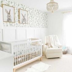 a baby's room with a crib, chair and pictures on the wall