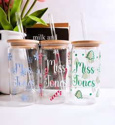 three personalized glass mason jars with wooden lids are sitting on a table next to a mug