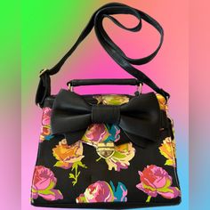 Fun, Bright Betsey Johnson Floral Bag! Nwot Black Background With Floral Pattern Gold Tone Hardware Fold Over Flap With Heart Hardware Closure Interior Features Signature Betsey Lining, 2 Slip Pockets & 1 Zip Pocket Measures Approximately: 8”H X 9”L X 2”D 2” Handle & 21” Adjustable/Detachable Crossbody Strap Nwot- Small Mark On Bottom From Storage (Please See Picture)- Never Used Smoke Free & Away From Pets Thank You For Visiting Kristine Retro Black Shoulder Bag For Summer, Black Shoulder Bag For Spring Day Out, Black Shoulder Bag For Day Out In Spring, Trendy Black Satchel For Spring, Black Bag For Day Out In Spring, Black Floral Print Shoulder Bag, Vintage Black Summer Bag, Retro Satchel For Spring, Vintage Black Bag For Summer