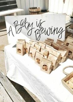 there is a sign that says baby is brewing next to some bags of bread on a table