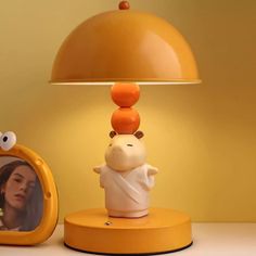 a lamp that is on top of a table next to a mirror and a stuffed animal