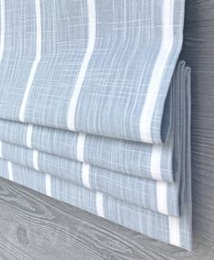 a close up view of a blue and white striped curtain with wood planks in the background