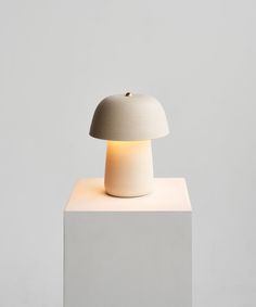 a white table lamp sitting on top of a block