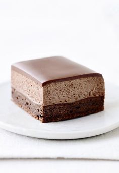 a piece of chocolate cake sitting on top of a white plate