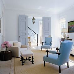 a living room with blue chairs and white walls