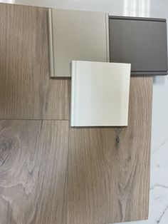 three different types of tile laying on the floor next to each other, one white and one gray