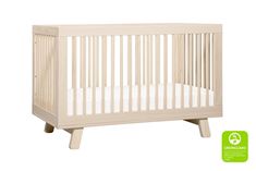 a white crib with a green sticker on the side