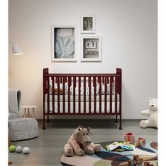 a baby crib with a stuffed animal on the floor