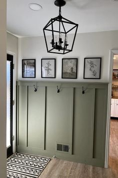 a room with some pictures on the wall and a light fixture hanging from the ceiling