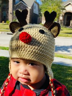 a little boy wearing a knitted reindeer hat