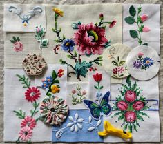 a bunch of different types of flowers on a piece of white fabric with buttons attached to it