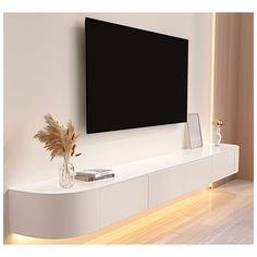 a white entertainment center with a large flat screen tv mounted on the wall above it