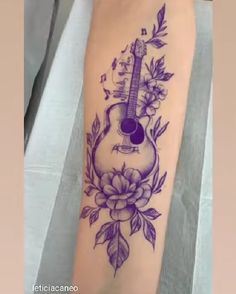 a tattoo with a guitar and flowers on it