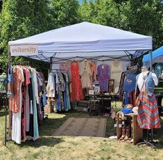 a tent with clothes on display at an outdoor market