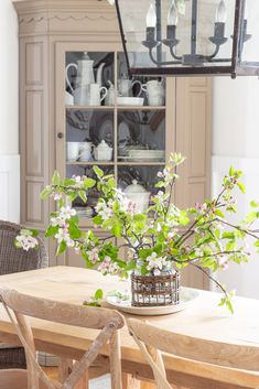 a dining room table with flowers in a vase