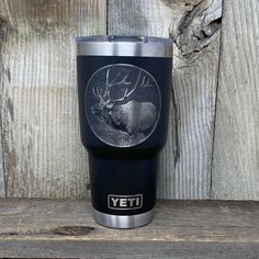 a stainless steel yeti cup with an image of a deer in the center on it