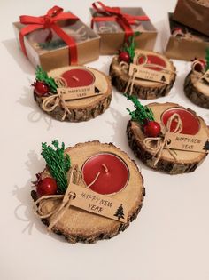 four wooden slices with christmas decorations on them sitting next to each other and wrapped in red ribbon