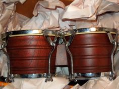 two wooden drums sitting on top of some white tissue covered flooring next to each other