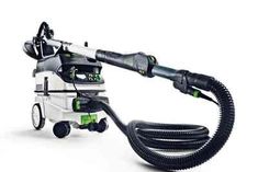 a green and white vacuum is shown with the hose attached to it's head