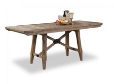 a wooden table with two glasses and fruit on it