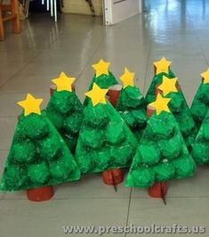 plastic christmas trees with yellow stars on them are sitting in a row and ready to be decorated